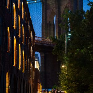 A group walking towards the Brooklyn Bridge on a warm summer night.